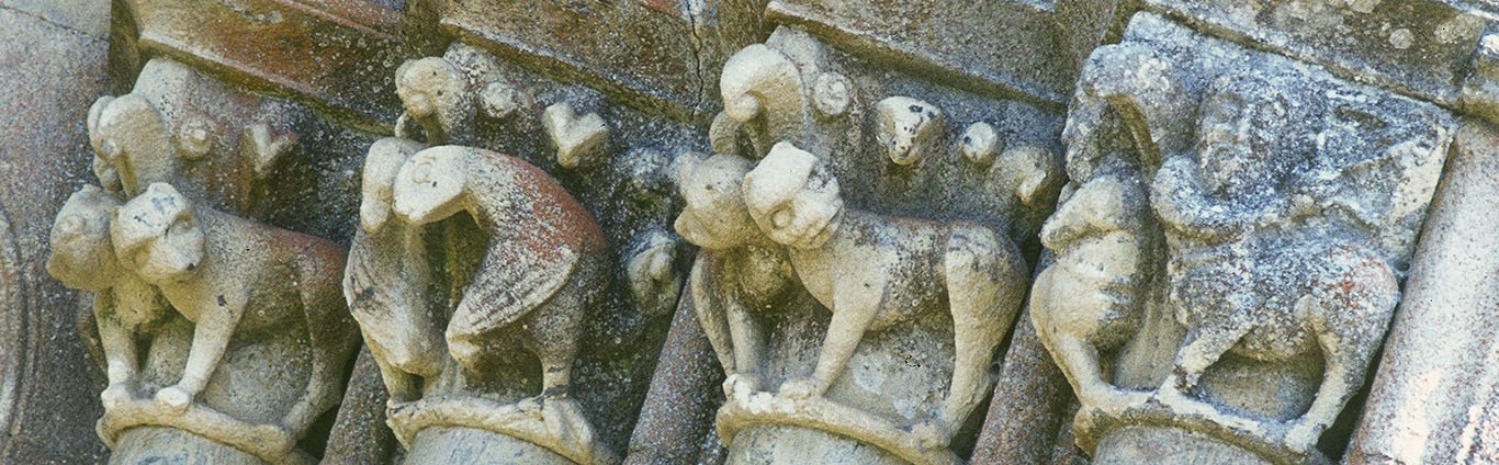 A row of four portal capitals with paired figures. Two have paired four-legged animals; one has a pair of addorsed birds twisting backwards so their heads meet at the corner; the outermost one has a pair of centaurs. Behind the animals, we can see the tops of volutes and cleft leaves with small balls at their tips.