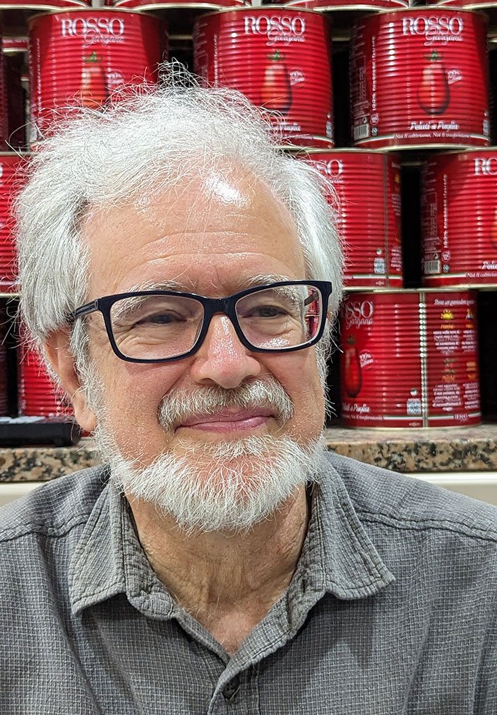 Portrait of me in front of stacks of canned tomatoes