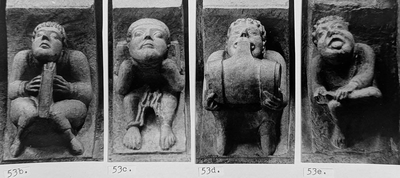 Black and white photos of four corbels, numbered as part of my PhD dissertation. On the four pieces, one man holds a book, one is chained to a burden on his back, one drinks from a barrel, one is posed like the thornpuller, holding his left foot on his right knee and sticking his tongue out.